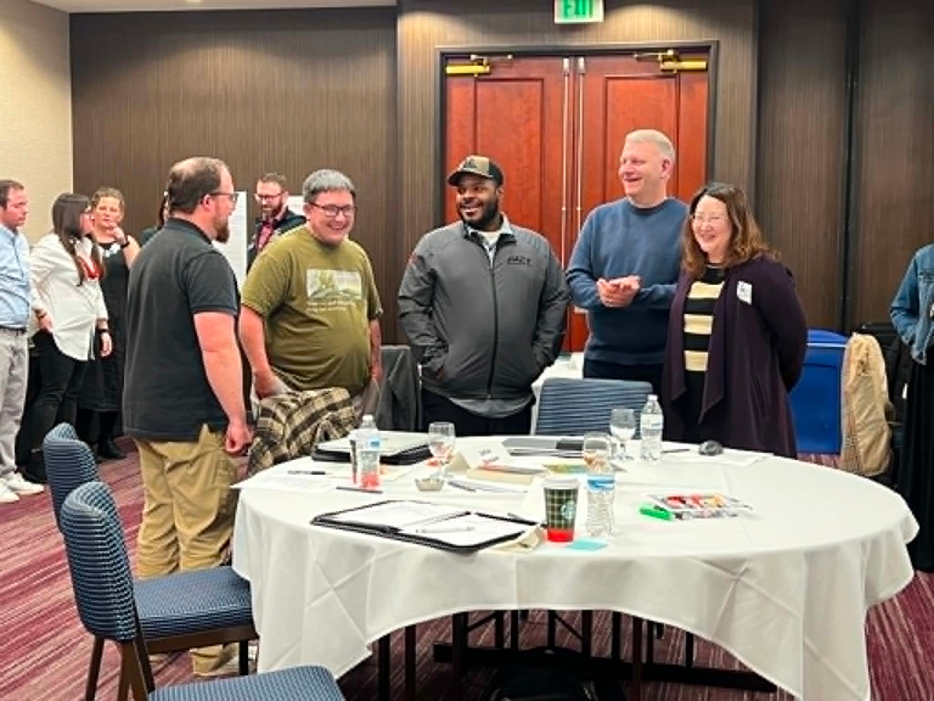Academy participants sharing a laugh around a work table