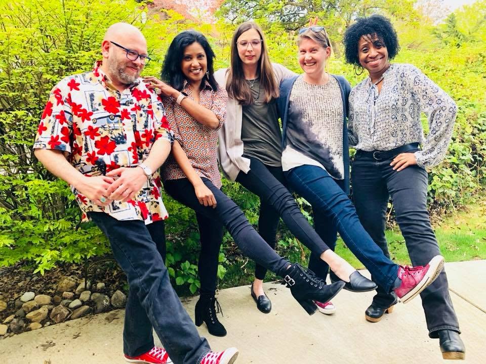 Five Academy participants kicking their legs out together in a playful line