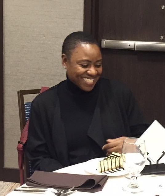 An Academy participant smiling at the table during a cohort dinner