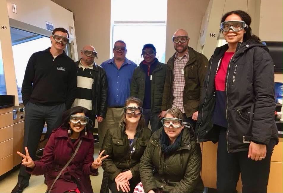 Academy participants wearing safety goggles during a campus lab tour