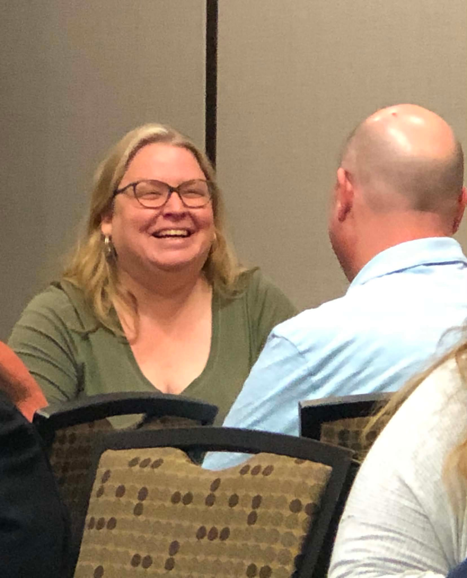 An Academy participant laughing during a table conversation