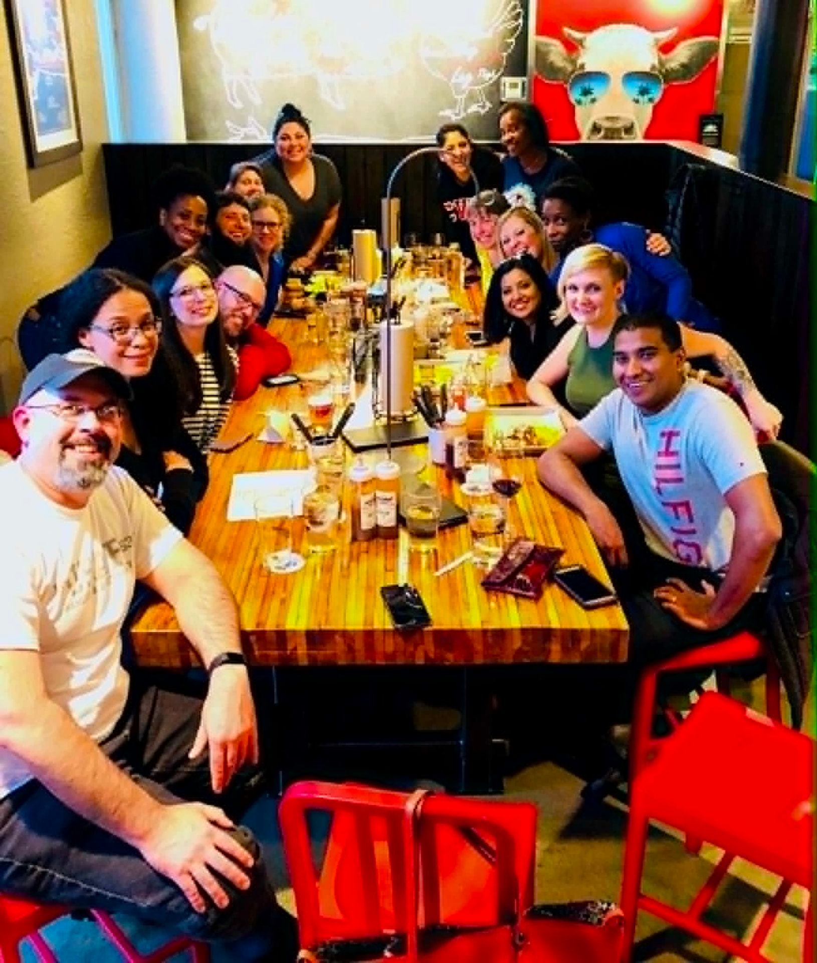 An Academy cohort gathered around a long restaurant table seen from above
