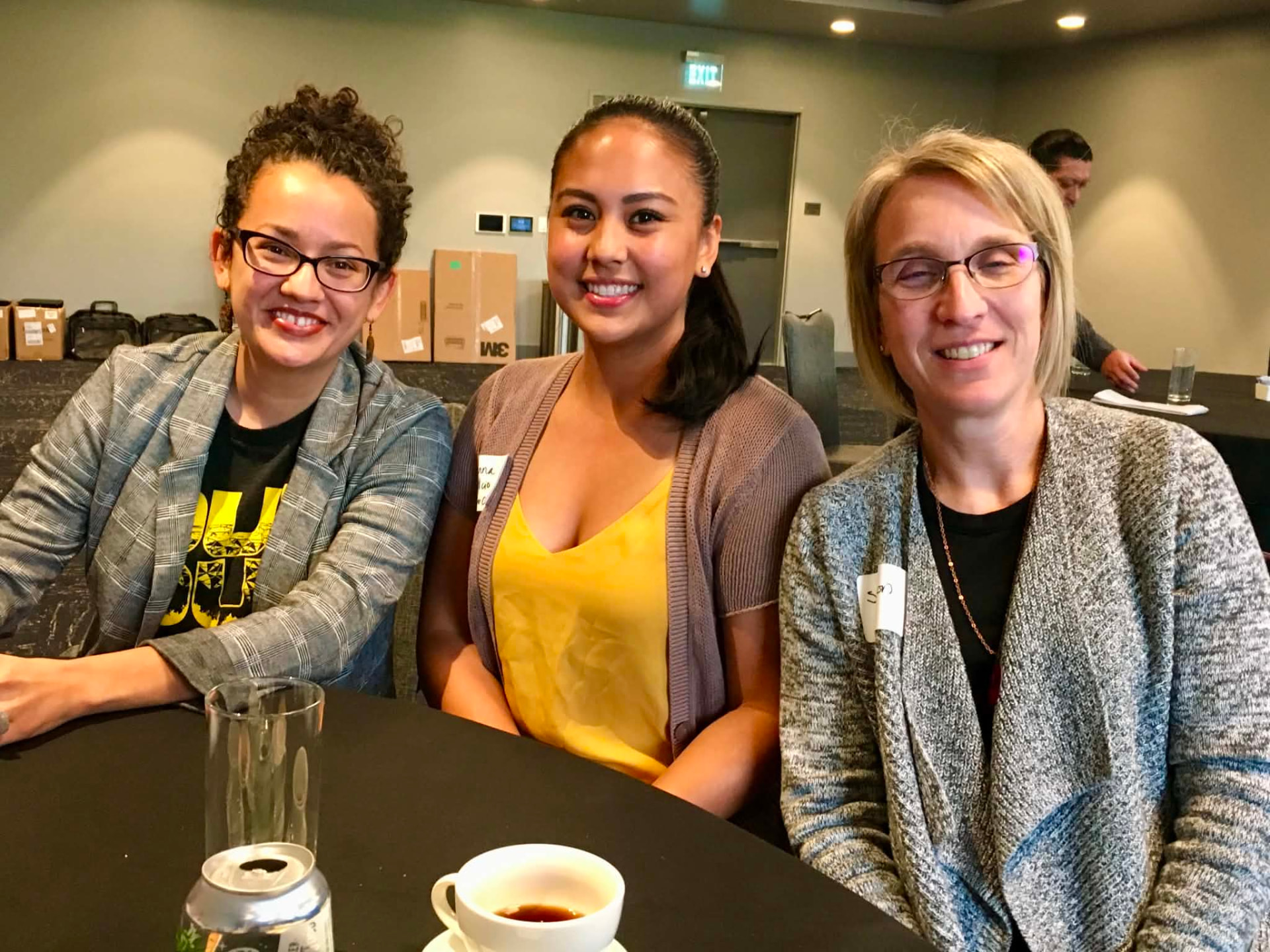 Three Academy participants seated together at a table between sessions